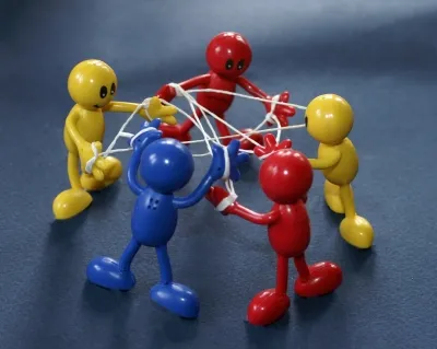 bunte Figuren verbunden durch Fäden