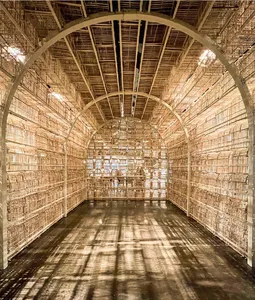 Ausstellung The Cage: ein Raum zu allen Seiten begrenzt von hölzernen Vogelkäfigen