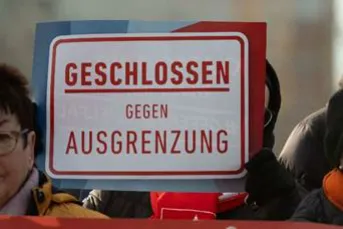 Menschenmenge it Schild: Geschlossen gegen Ausgrezung