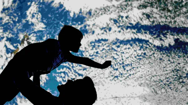 Silhouette erwachsene Person die ein Kind in Supermanpose hochhebt
