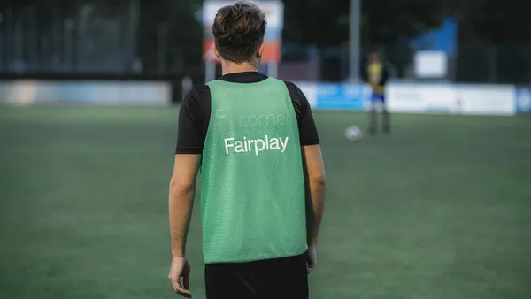Schiedsrichter auf dem Fussballplatz, auf seinem Trikot steht Fairplay