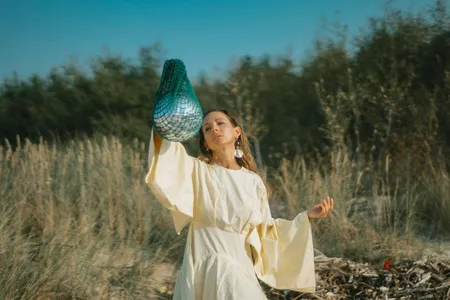 Frau in Gewand betrachtet silbernen Ball