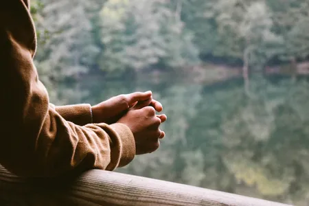 Arme auf Geländer an Wald-See gestützt